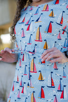 Model wearing Nuggles® Nola Sport Swim Dress in Harbor Sailboats 
