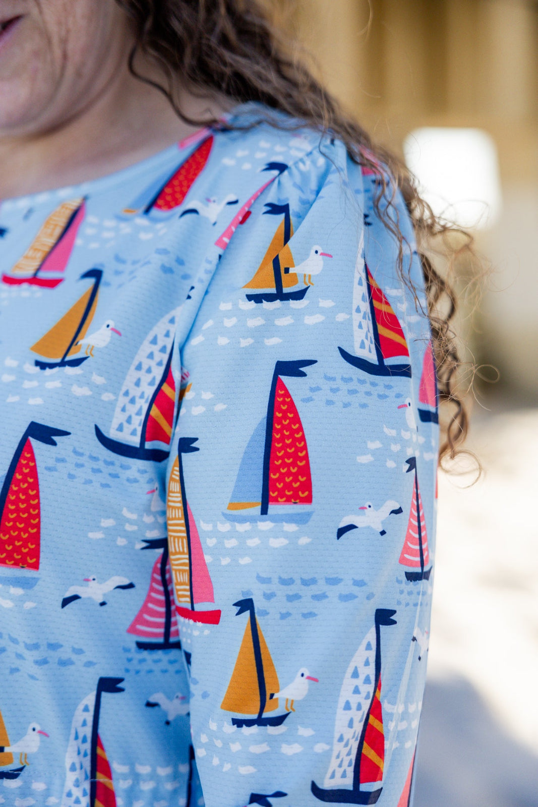 Model wearing Nuggles® Nola Sport Swim Dress in Harbor Sailboats 