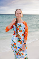 Model wearing Nuggles® Sport Swim Dress in Citrus Picnic