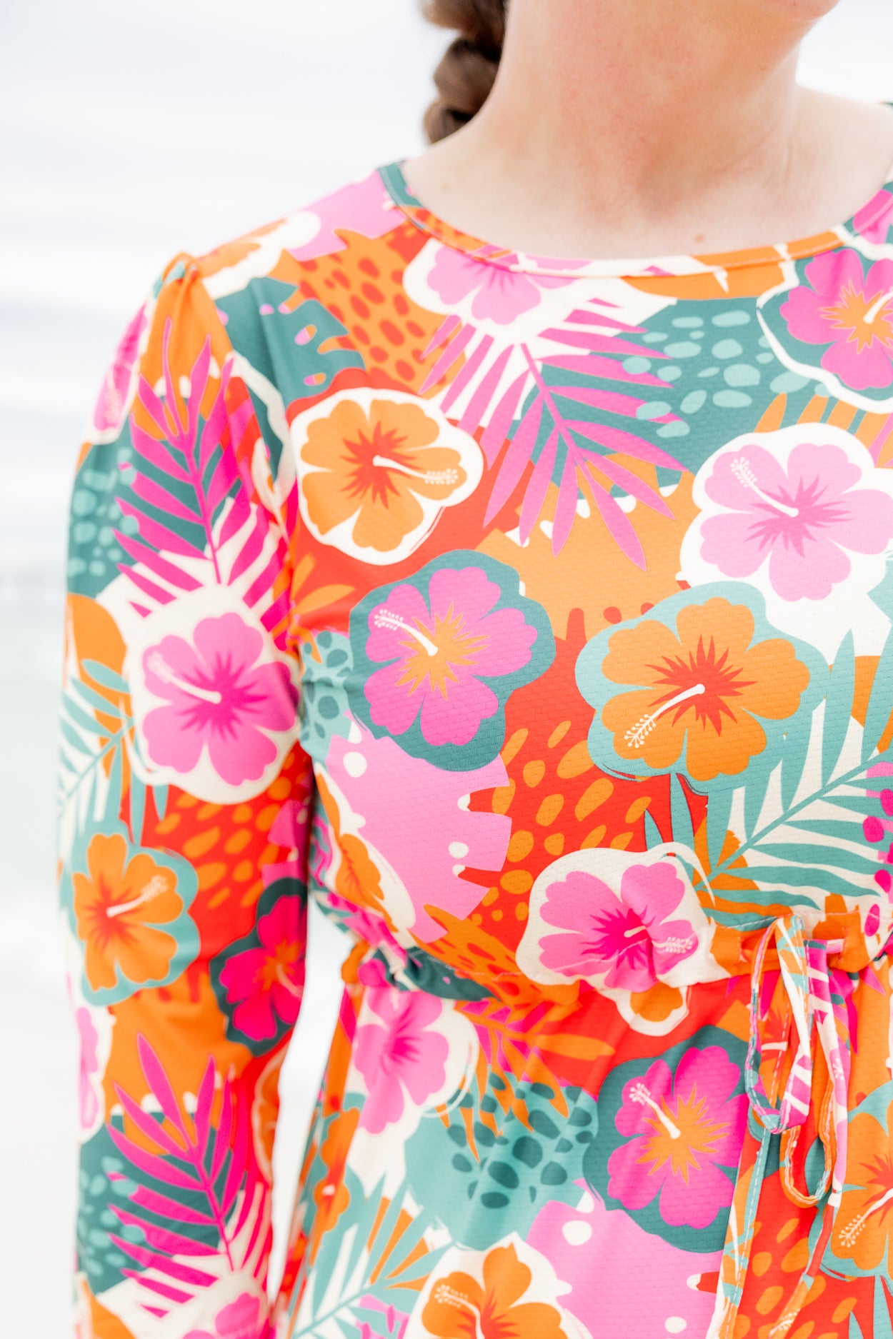 Model wearing Nuggles® Nola Sport Swim Dress in Luau Garden