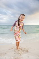 Model wearing Nuggles® Girls' Sport Swim Dress in Ribbon Scribbles