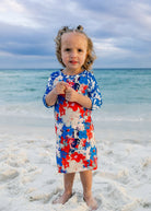 Model wearing Nuggles® Girls' Sport Swim Dress in Firecracker Garden