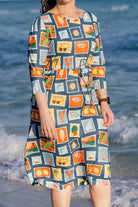 Model wearing Nuggles® Nola Sport Swim Dress in Retro Postcards