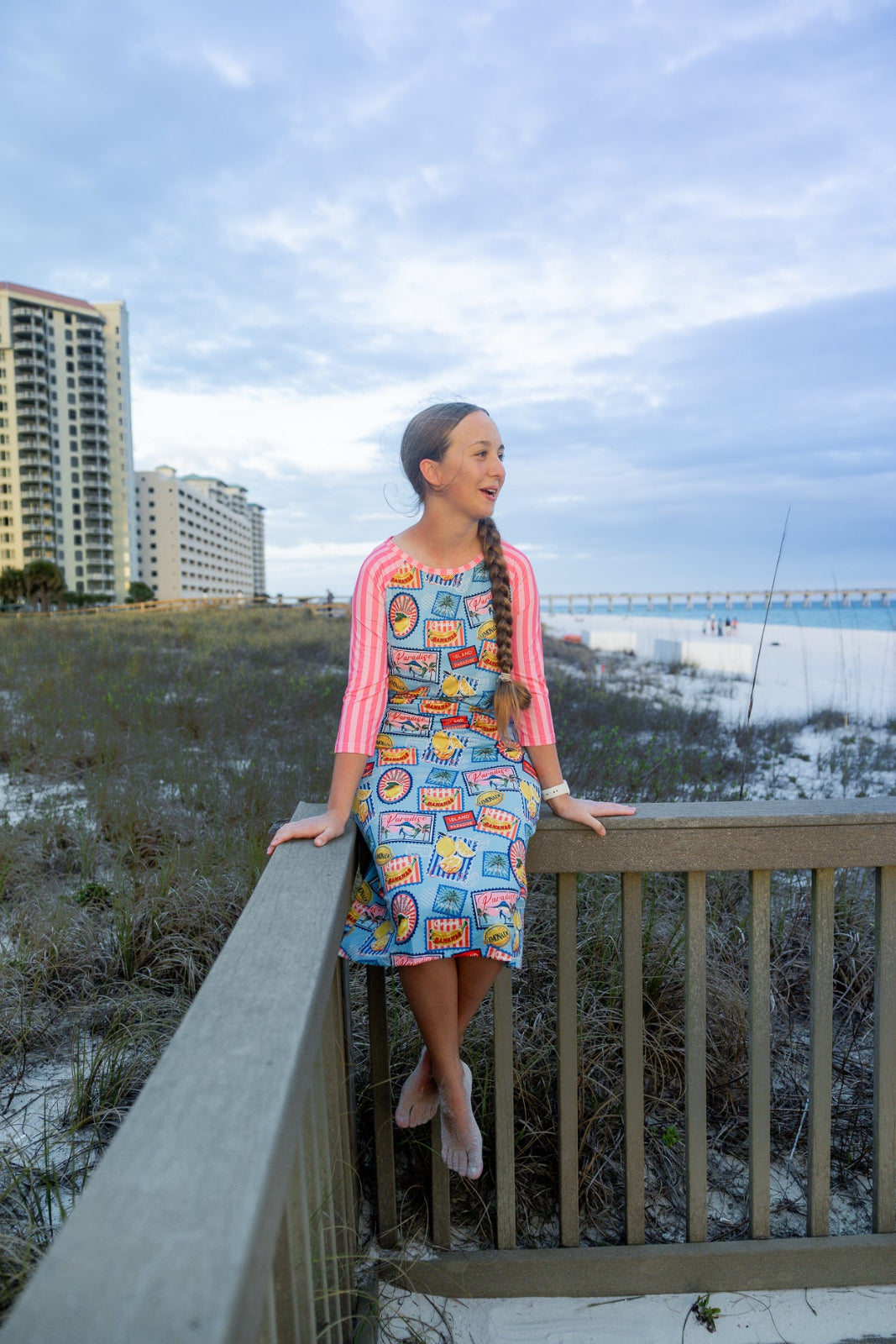 Model wearing Nuggles® Sport Swim Dress in Vacation Postcards