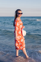 Model wearing Nuggles® Carlie Swim Dress in Sunset Hibiscus