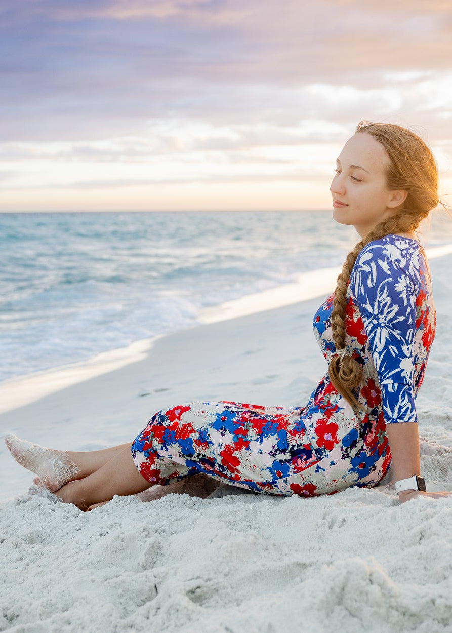 Model wearing Nuggles® Sport Swim Dress in Firecracker Garden