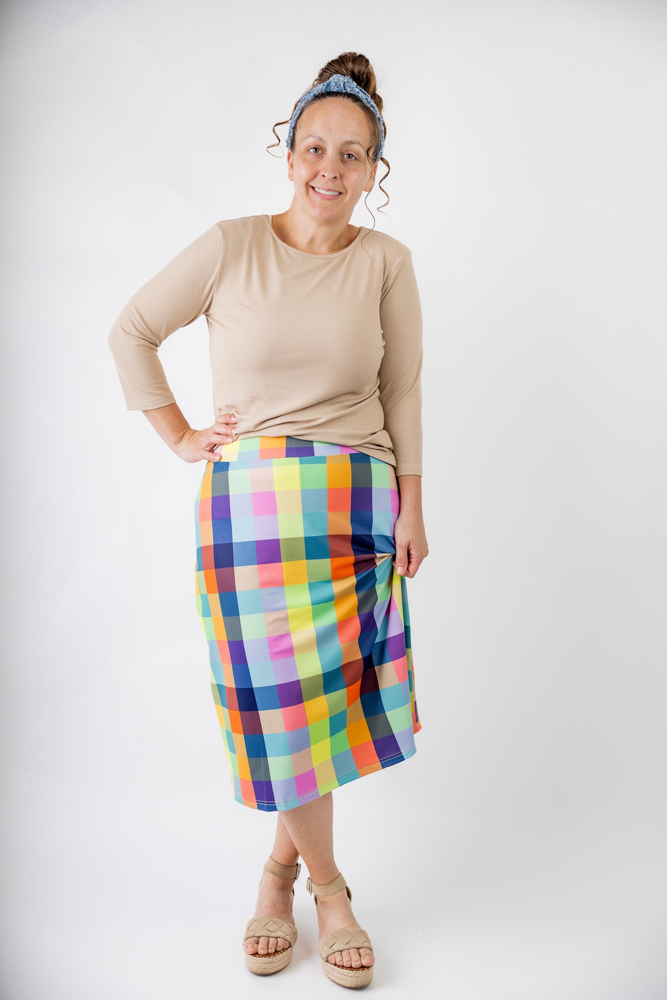 Model wearing Nuggles® Jaxon Plaid 27-inch All Sport Skirt with built-in leggings, featuring vibrant multicolor plaid pattern. Modest athletic skirt for women, designed for activewear and everyday comfort.