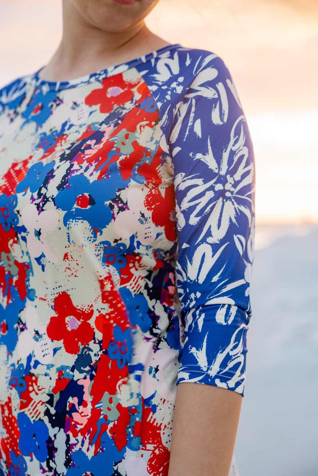 Model wearing Nuggles® Sport Swim Dress in Firecracker Garden