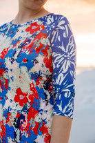 Model wearing Nuggles® Sport Swim Dress in Firecracker Garden