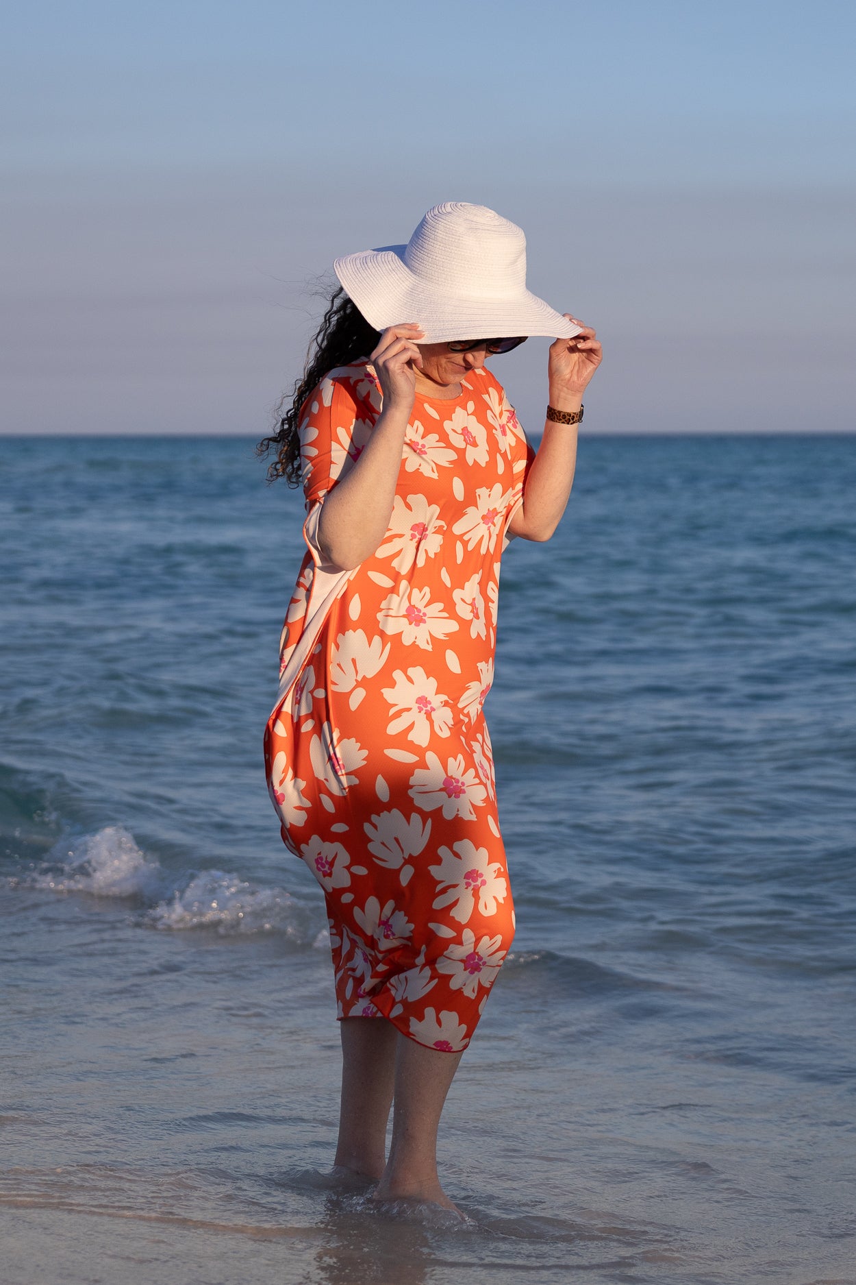 Model wearing Nuggles® Carlie Swim Dress in Sunset Hibiscus