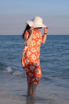 Model wearing Nuggles® Carlie Swim Dress in Sunset Hibiscus