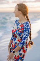 Model wearing Nuggles® Sport Swim Dress in Firecracker Garden