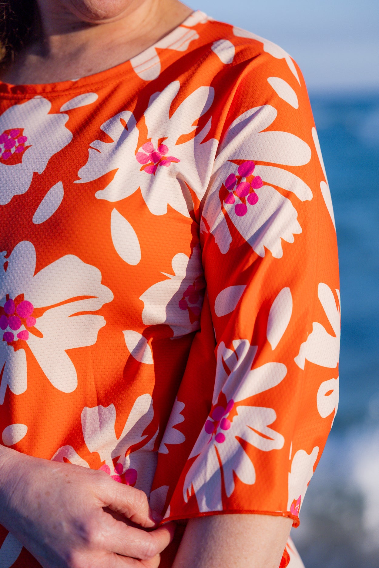 Model wearing Nuggles® Carlie Swim Dress in Sunset Hibiscus