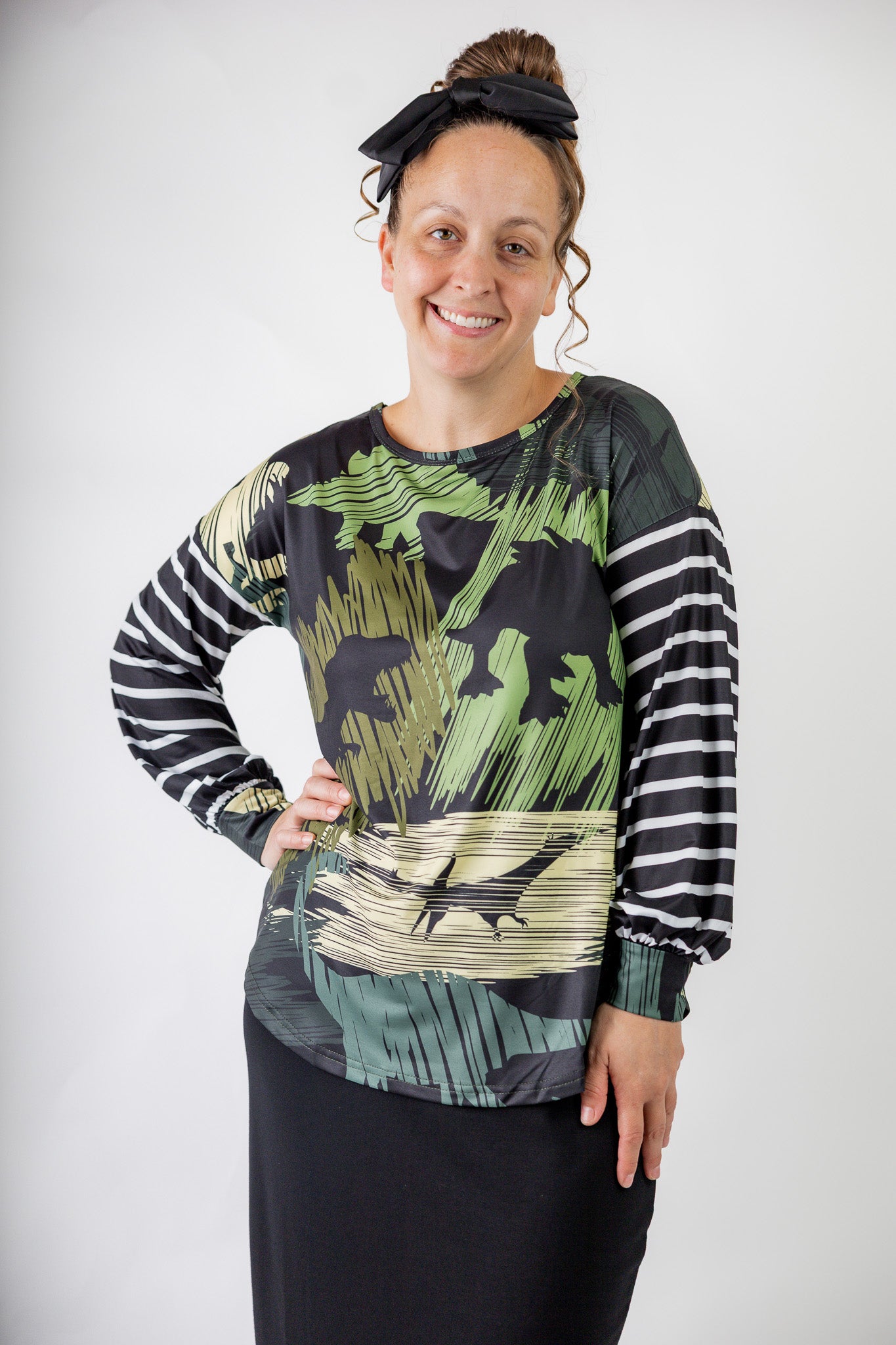 Model wearing the Nuggles® Jaxon Bryauna Top, a long-sleeve modest shirt with dinosaur and stripe print, styled for everyday wear and created as part of a fundraiser in honor of Jaxon.