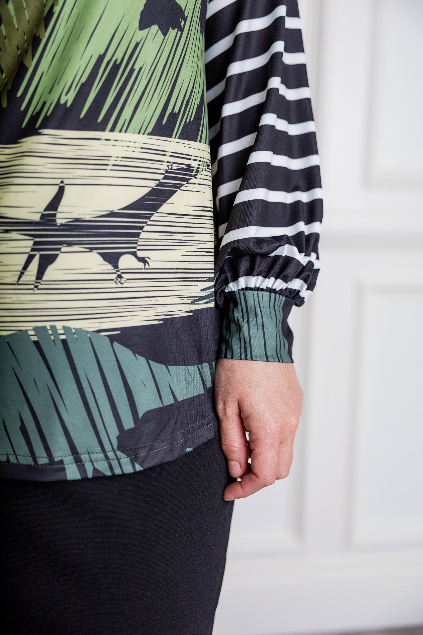 Model wearing the Nuggles® Jaxon Bryauna Top, a long-sleeve modest shirt with dinosaur and stripe print, styled for everyday wear and created as part of a fundraiser in honor of Jaxon.