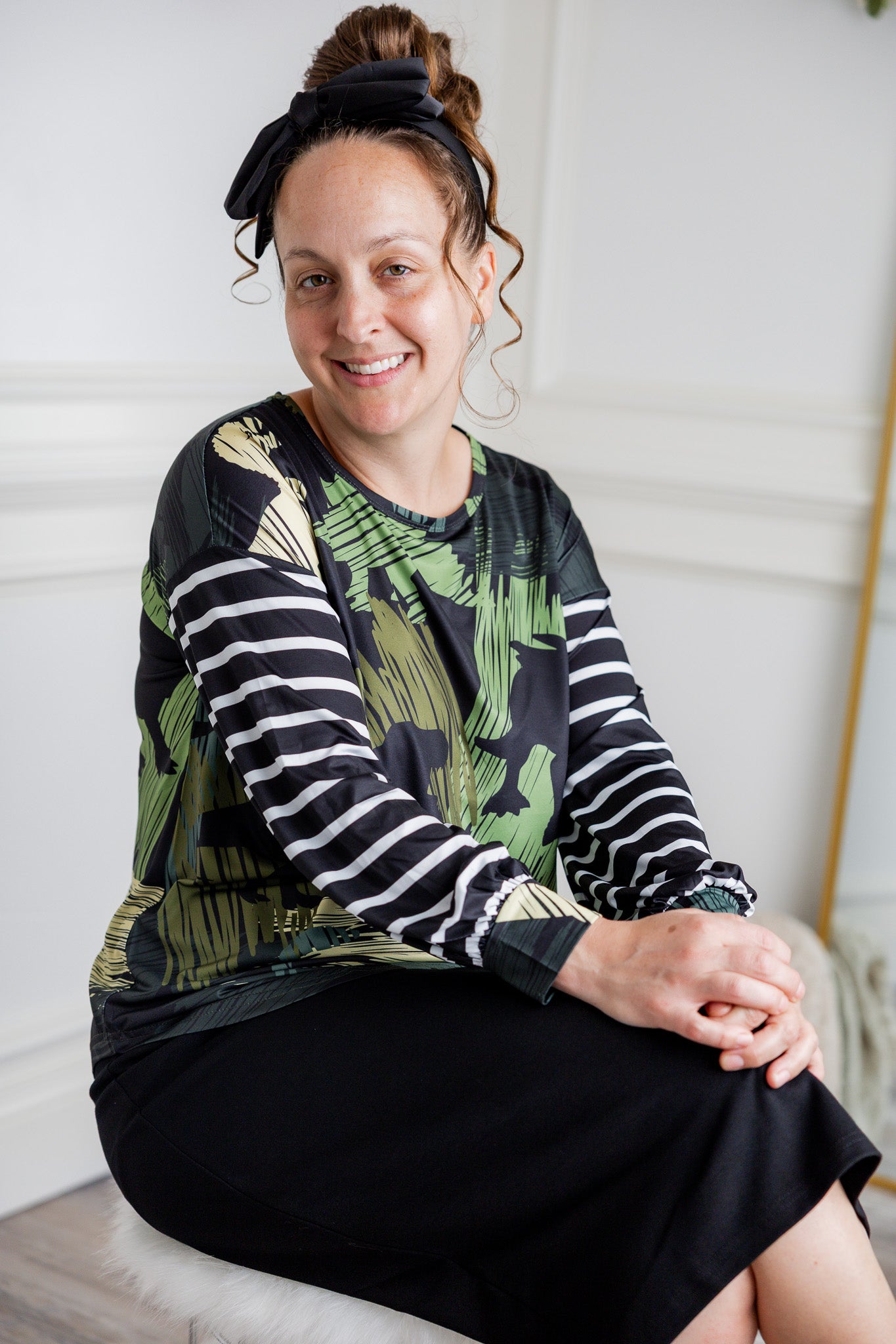 Model wearing the Nuggles® Jaxon Bryauna Top, a long-sleeve modest shirt with dinosaur and stripe print, styled for everyday wear and created as part of a fundraiser in honor of Jaxon.