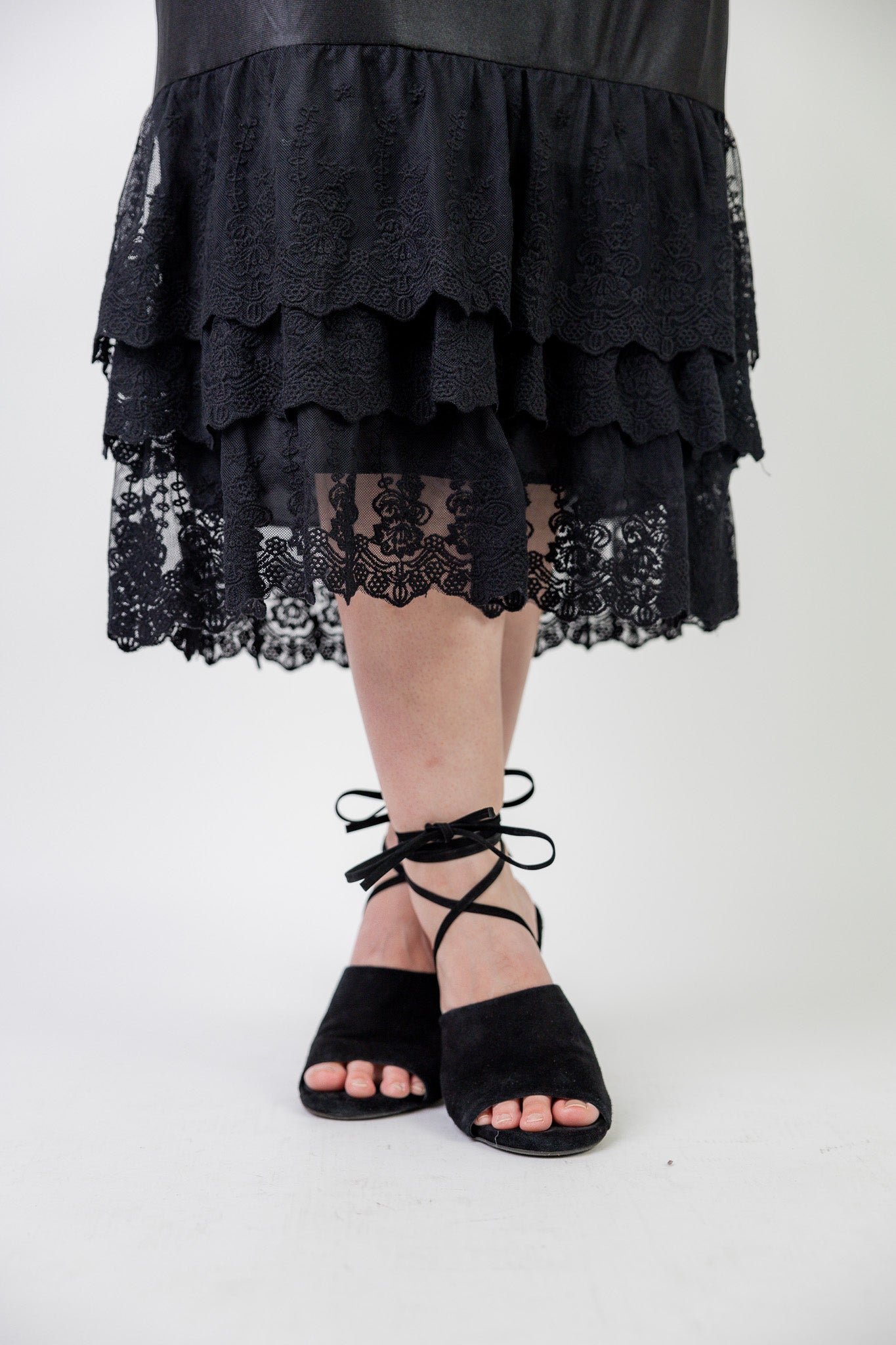 Model wearing 27" lace layering slip with tiered lace hem, designed for modest layering under skirts or dresses.