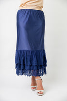 Model wearing 27" lace layering slip with tiered lace hem, designed for modest layering under skirts or dresses.