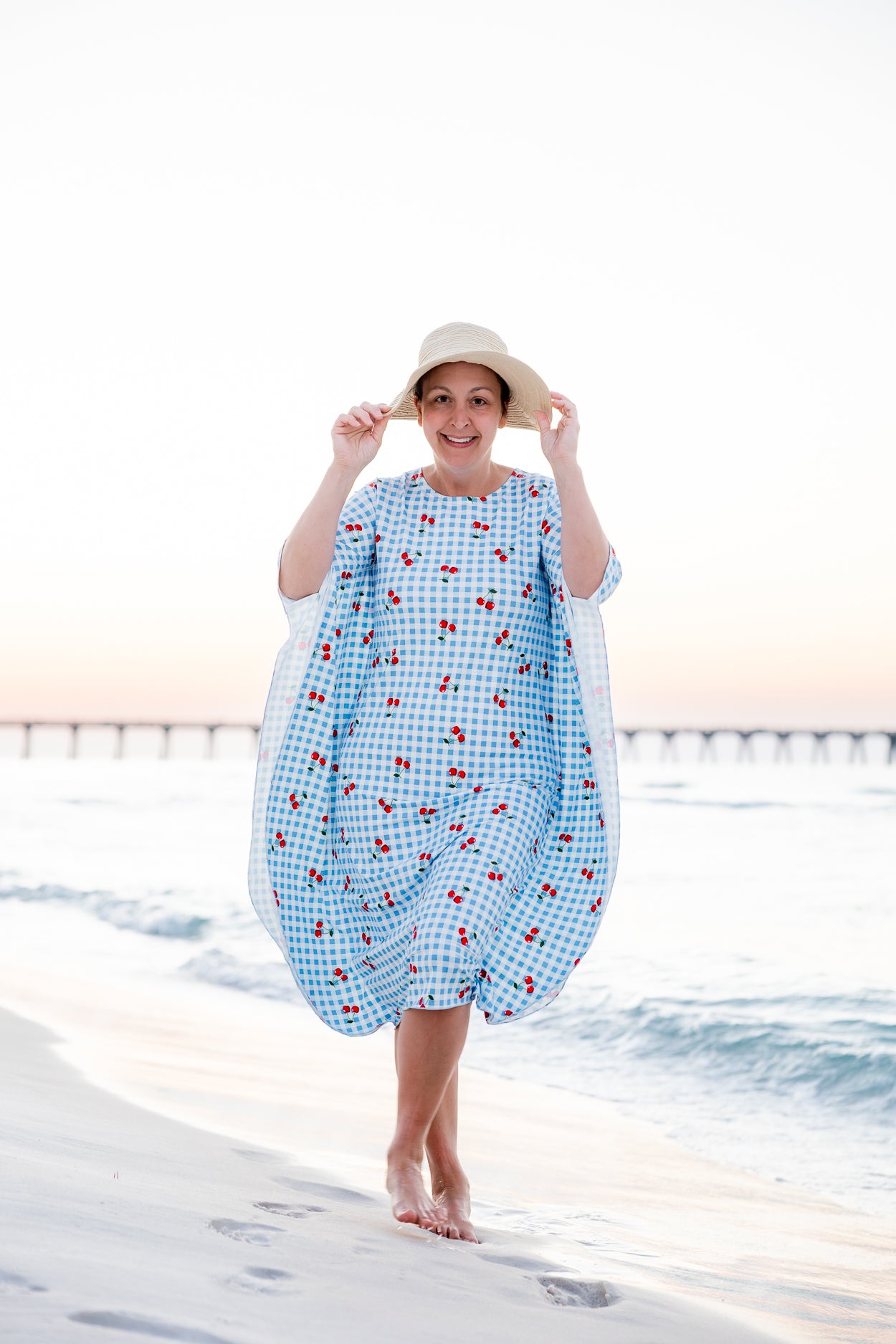 Model wearing Nuggles® Carlie Swim Dress in Sweet Cherry Check