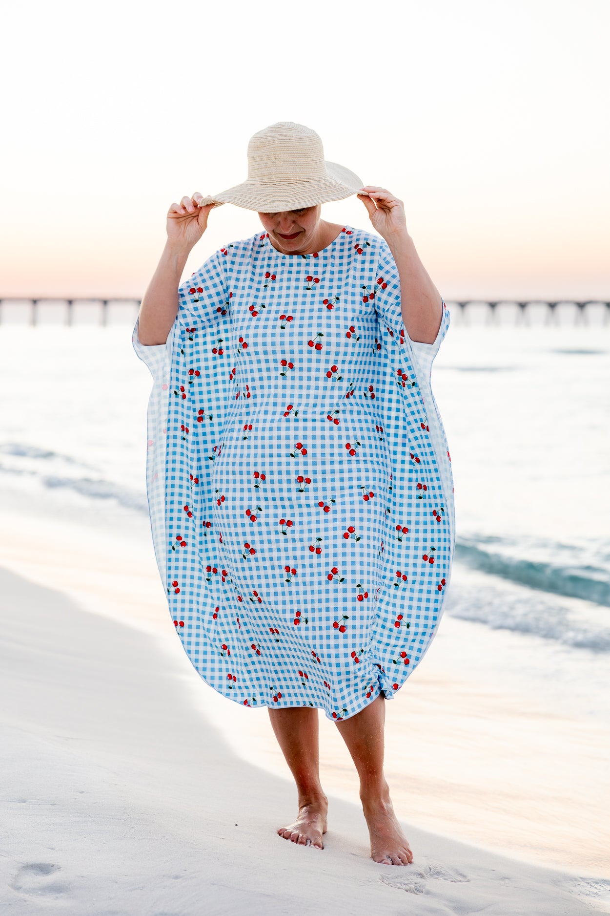 Model wearing Nuggles® Carlie Swim Dress in Sweet Cherry Check