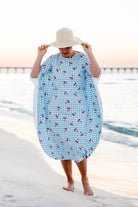 Model wearing Nuggles® Carlie Swim Dress in Sweet Cherry Check