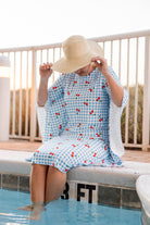 Model wearing Nuggles® Carlie Swim Dress in Sweet Cherry Check