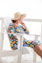 Model wearing Nuggles® Nola Sport Swim Dress in Retro Postcards