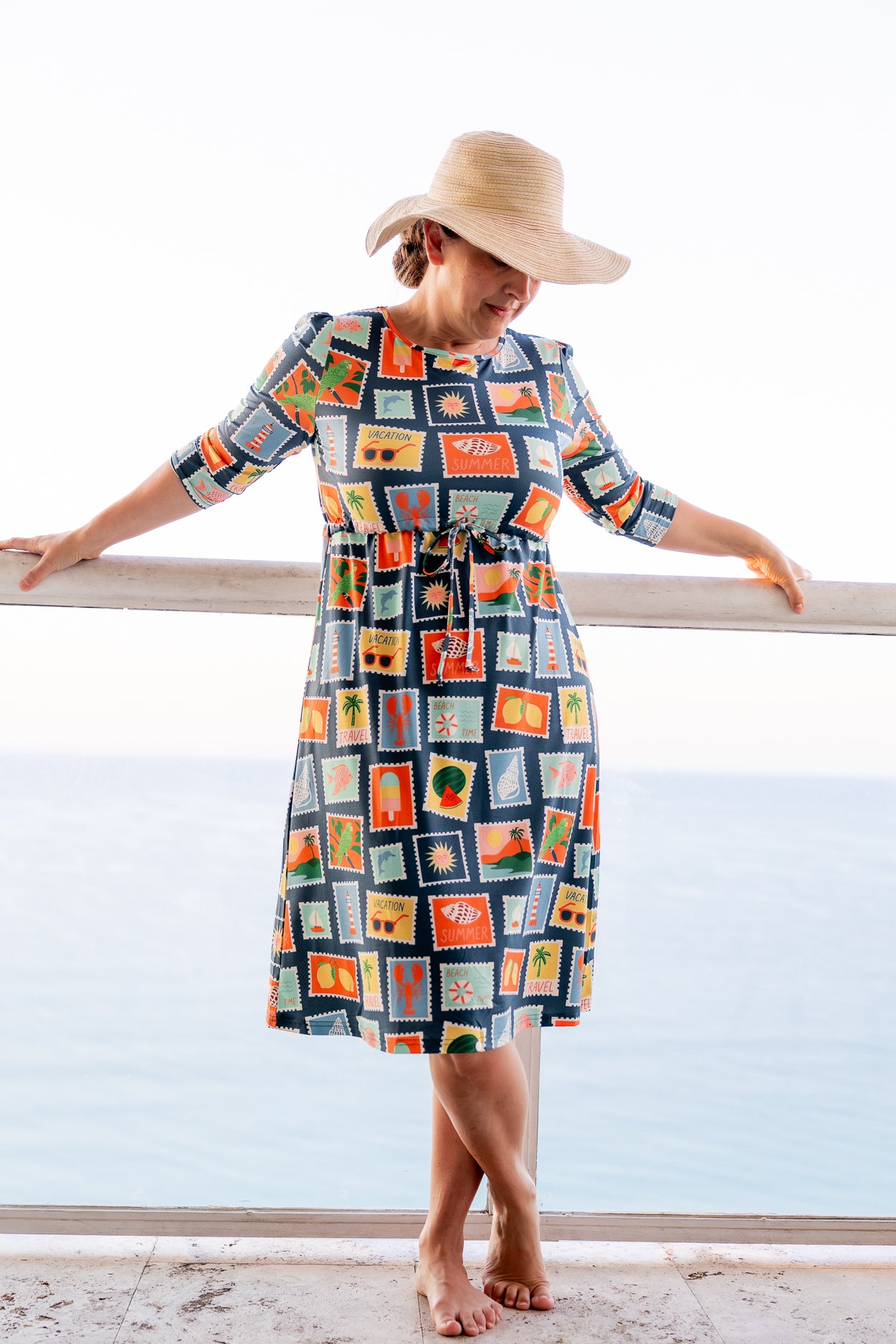 Model wearing Nuggles® Nola Sport Swim Dress in Retro Postcards