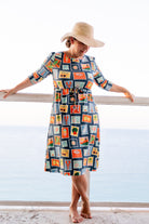 Model wearing Nuggles® Nola Sport Swim Dress in Retro Postcards