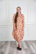 Woman modeling a Nuggles pattern midi dress made from soft, stretchy knit fabric, featuring long sleeves and side pockets.