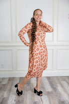 Woman modeling a Nuggles pattern midi dress made from soft, stretchy knit fabric, featuring long sleeves and side pockets.