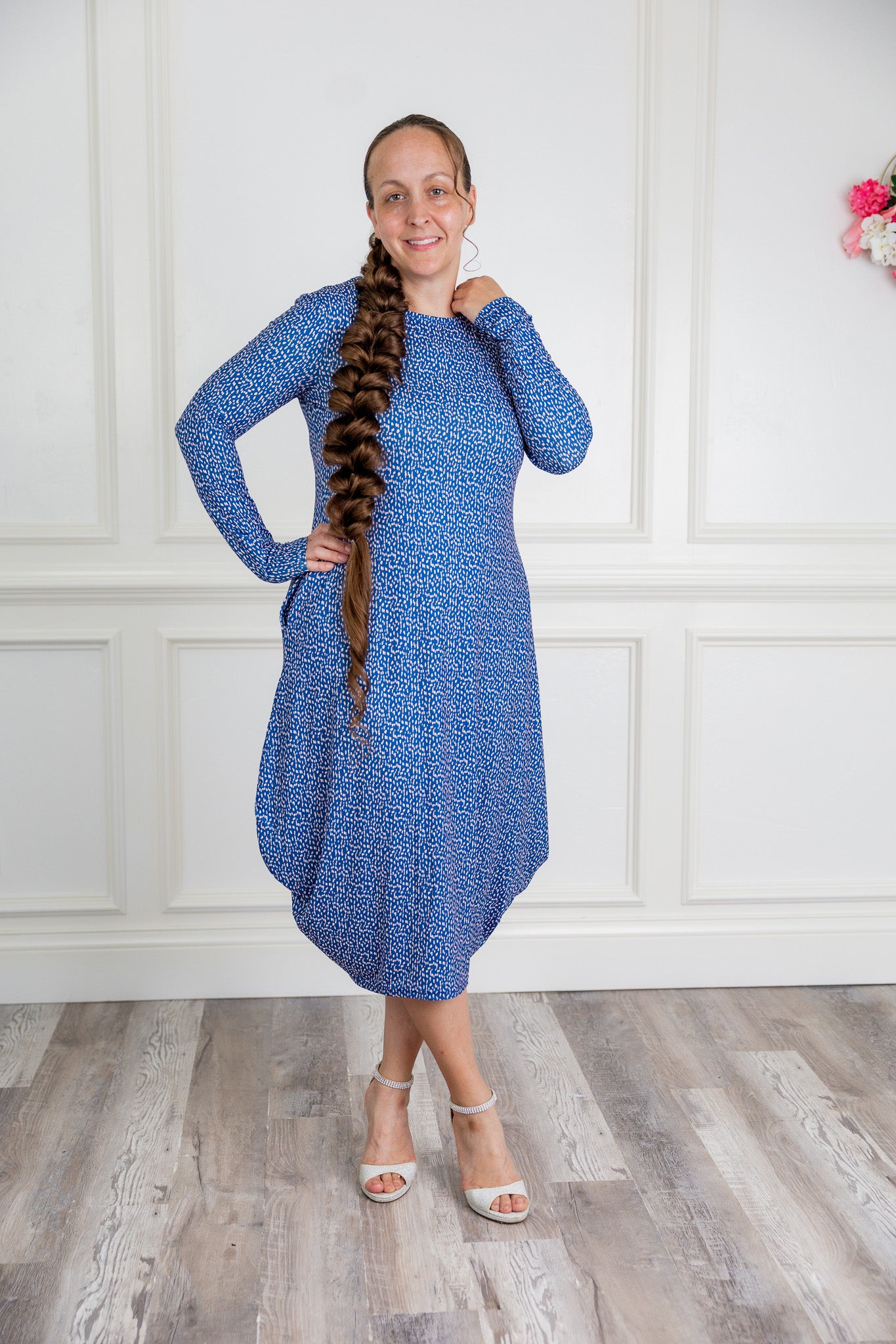Woman modeling a Nuggles blue pattern midi dress made from soft, stretchy knit fabric, featuring long sleeves and side pockets.