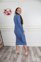 Woman modeling a Nuggles blue pattern midi dress made from soft, stretchy knit fabric, featuring long sleeves and side pockets.