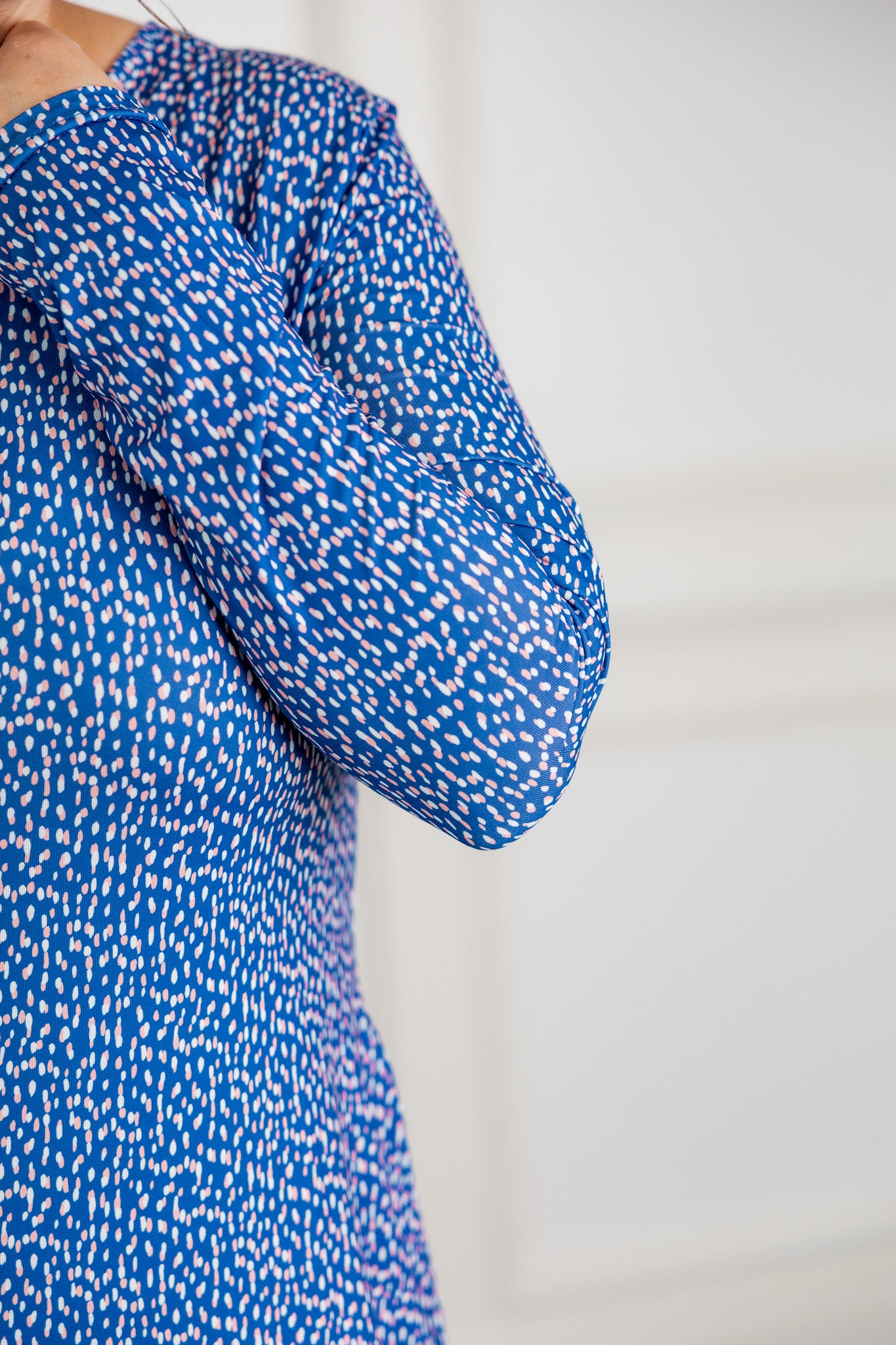 Blue patterned blouse with long sleeves on a plain background