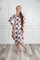 Woman modeling a Nuggles floral print midi dress made from soft, stretchy knit fabric, featuring long sleeves and side pockets.
