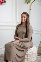 Nuggles® Farah Dress in solid color, modest long sleeve midi dress with empire waist, styled with flats for everyday wear.