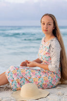 Model wearing Nuggles® Sport Swim Dress in Seaside Cottages