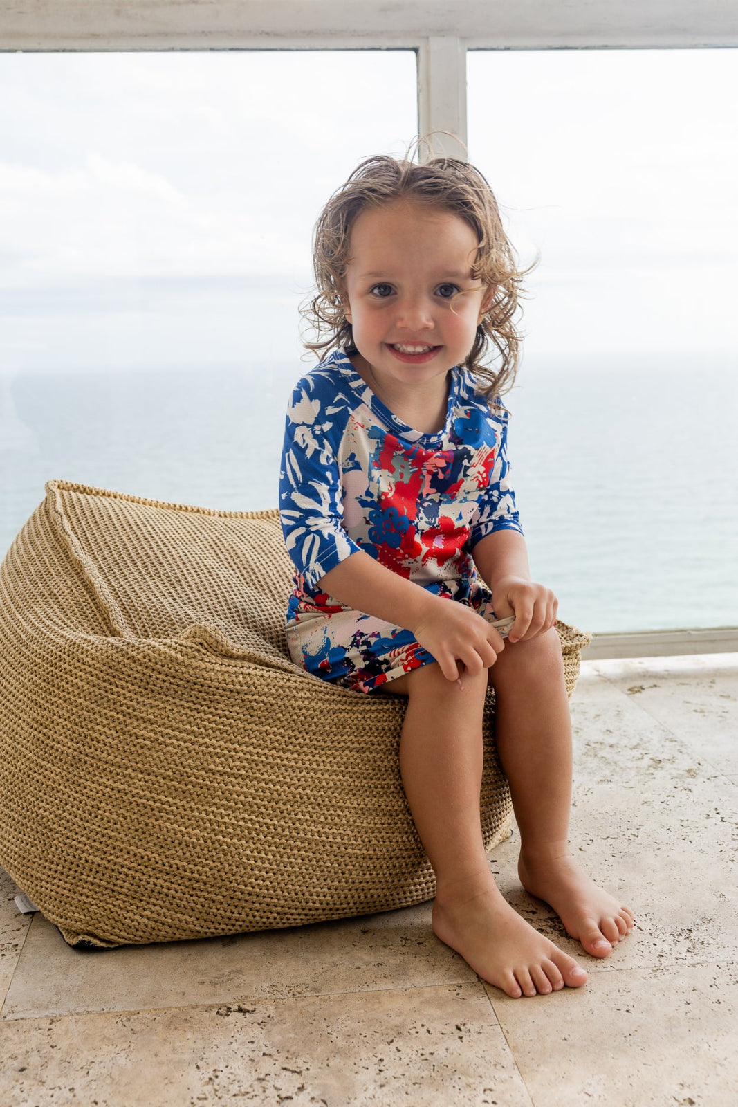 Model wearing Nuggles® Girls' Sport Swim Dress in Firecracker Garden