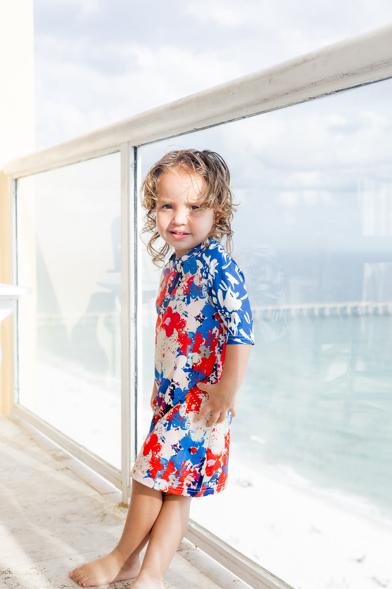 Model wearing Nuggles® Girls' Sport Swim Dress in Firecracker Garden