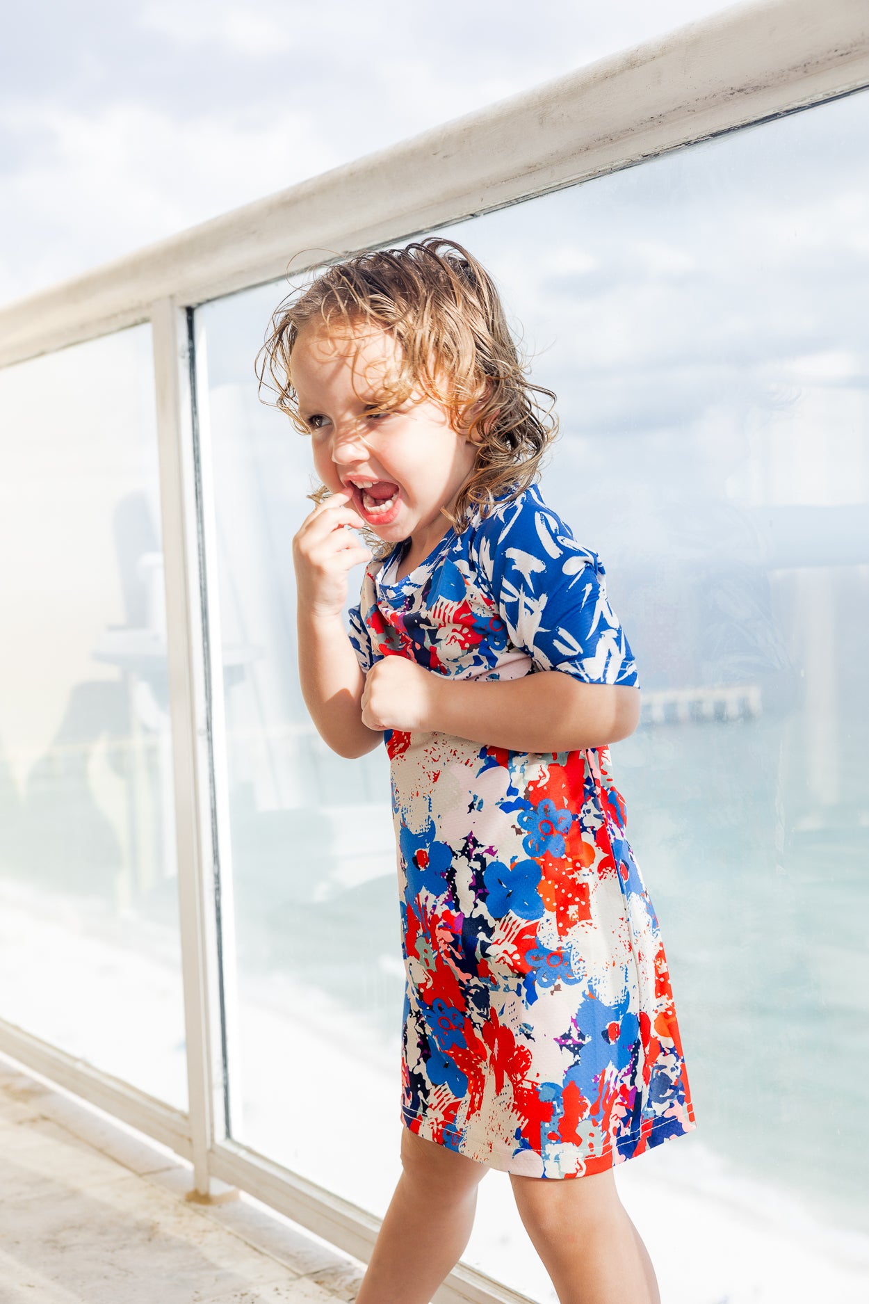 Model wearing Nuggles® Girls' Sport Swim Dress in Firecracker Garden