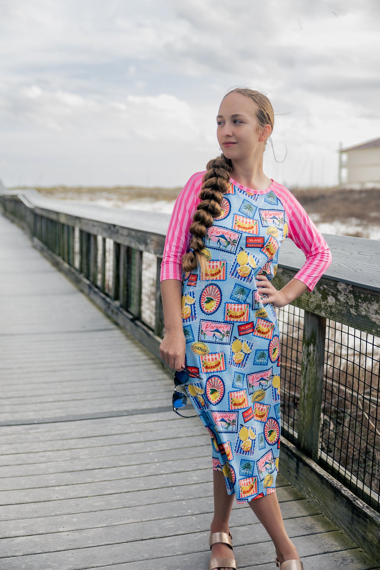 Model wearing Nuggles® Sport Swim Dress in Vacation Postcards