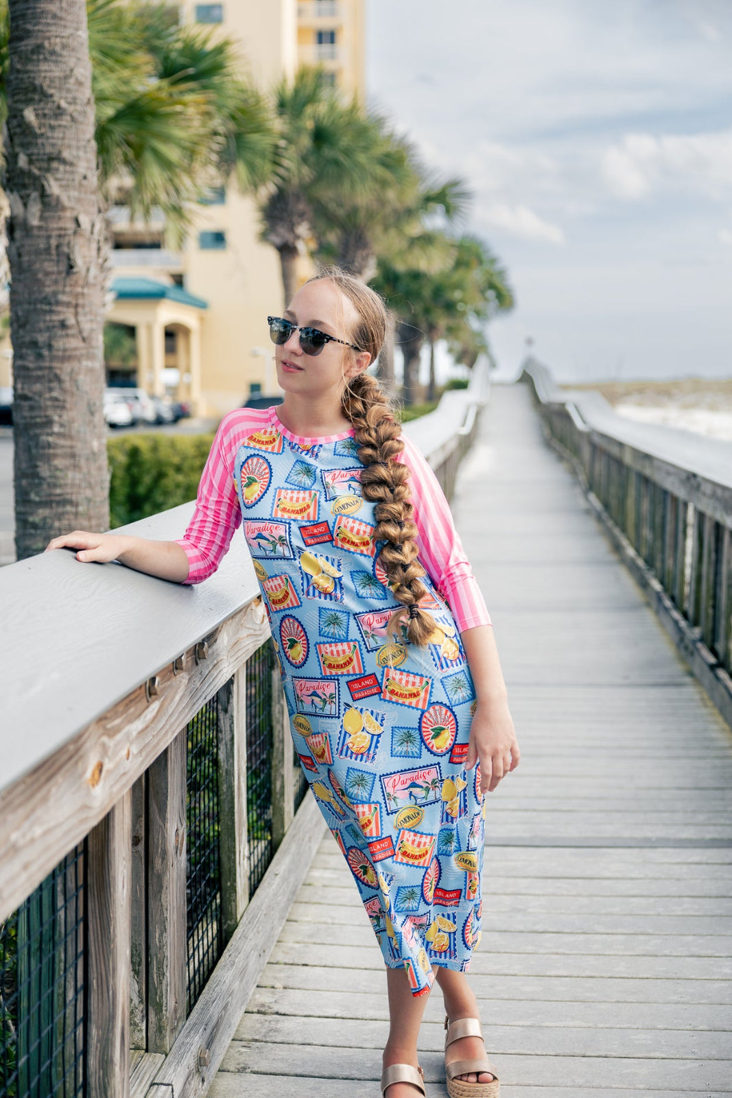 Model wearing Nuggles® Sport Swim Dress in Vacation Postcards
