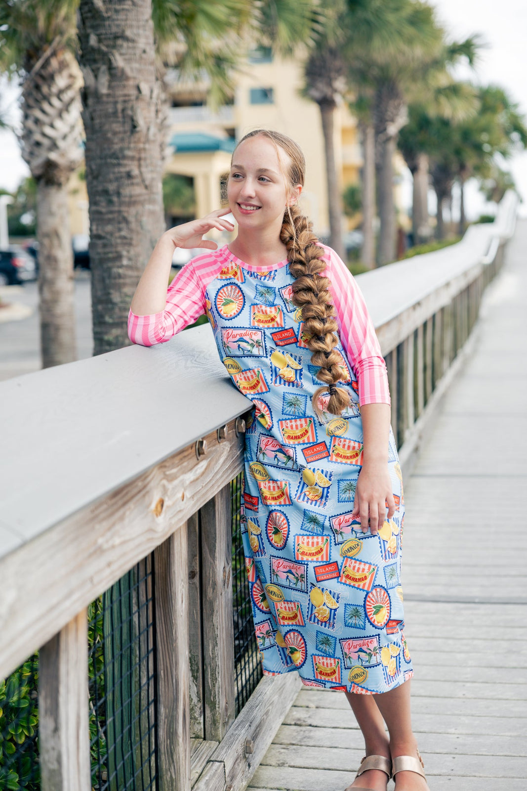 Model wearing Nuggles® Sport Swim Dress in Vacation Postcards