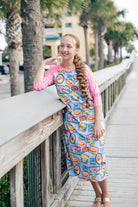 Model wearing Nuggles® Sport Swim Dress in Vacation Postcards