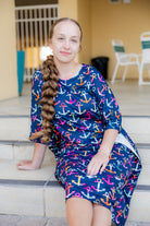 Model wearing Nuggles® Carlie Swim Dress in Nautical Nights