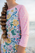 Model wearing Nuggles® Sport Swim Dress in Daisy Daydream