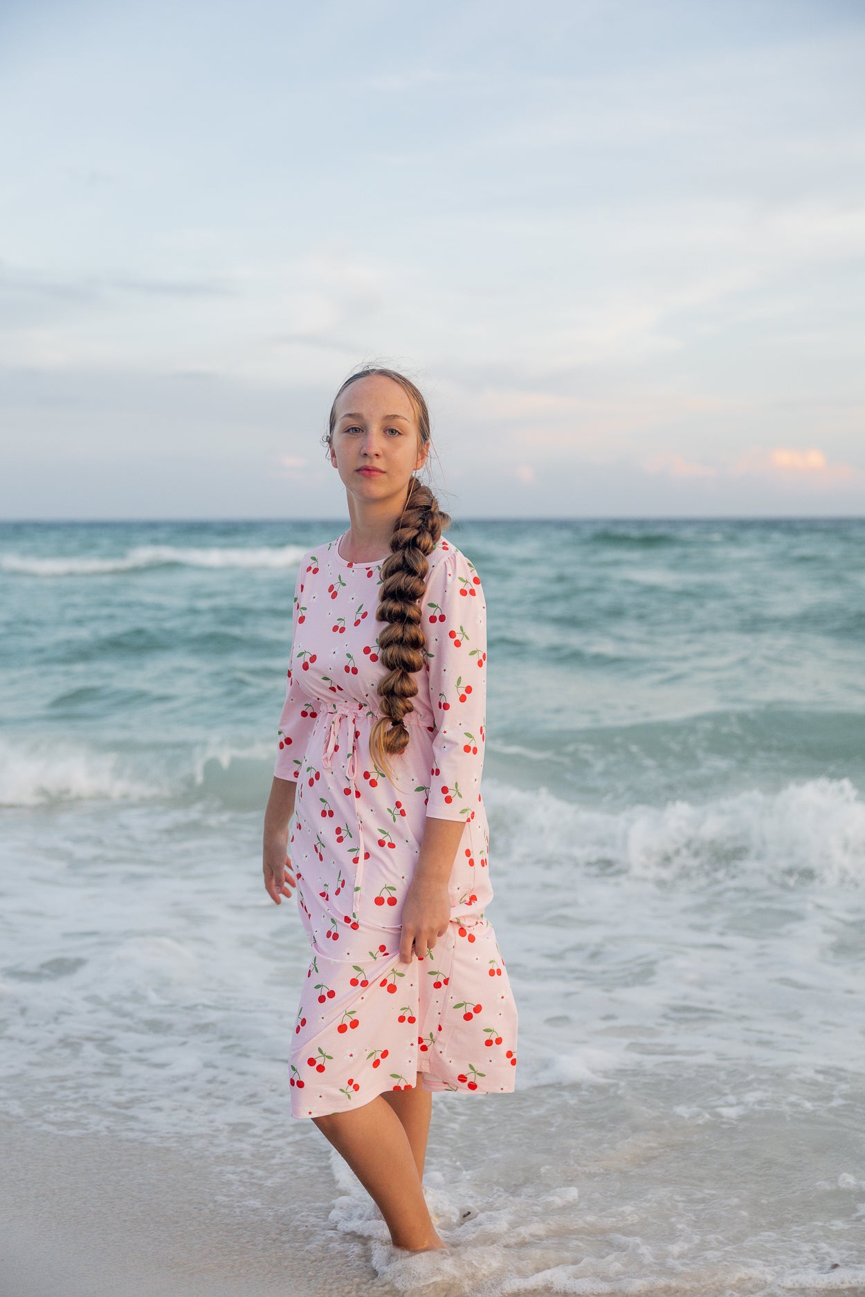 Model wearing Nuggles® Nola Sport Swim Dress in Cherry Soda Shop