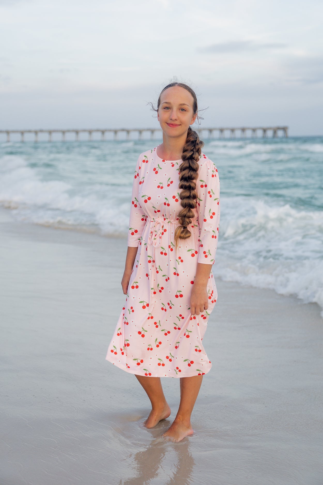 Model wearing Nuggles® Nola Sport Swim Dress in Cherry Soda Shop