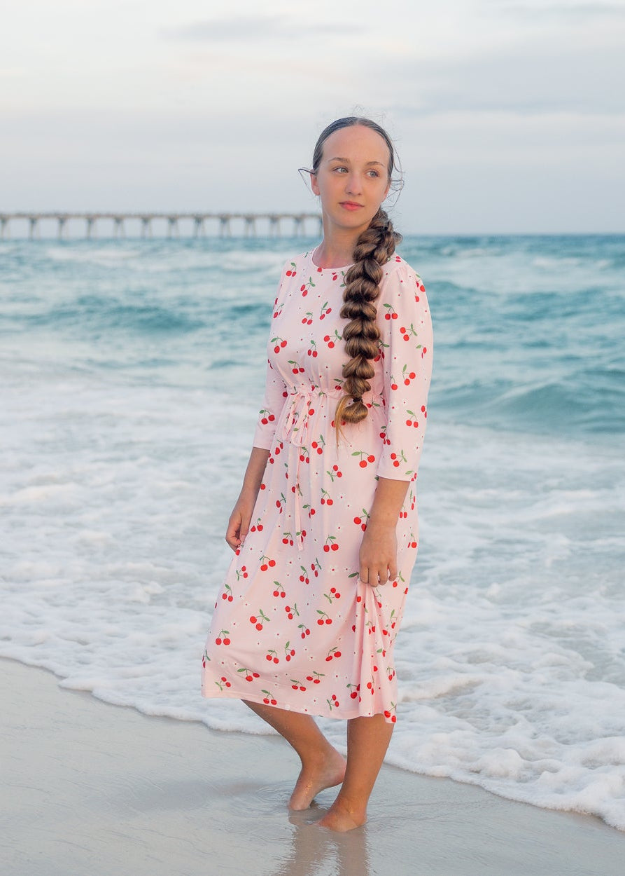 Model wearing Nuggles® Nola Sport Swim Dress in Cherry Soda Shop