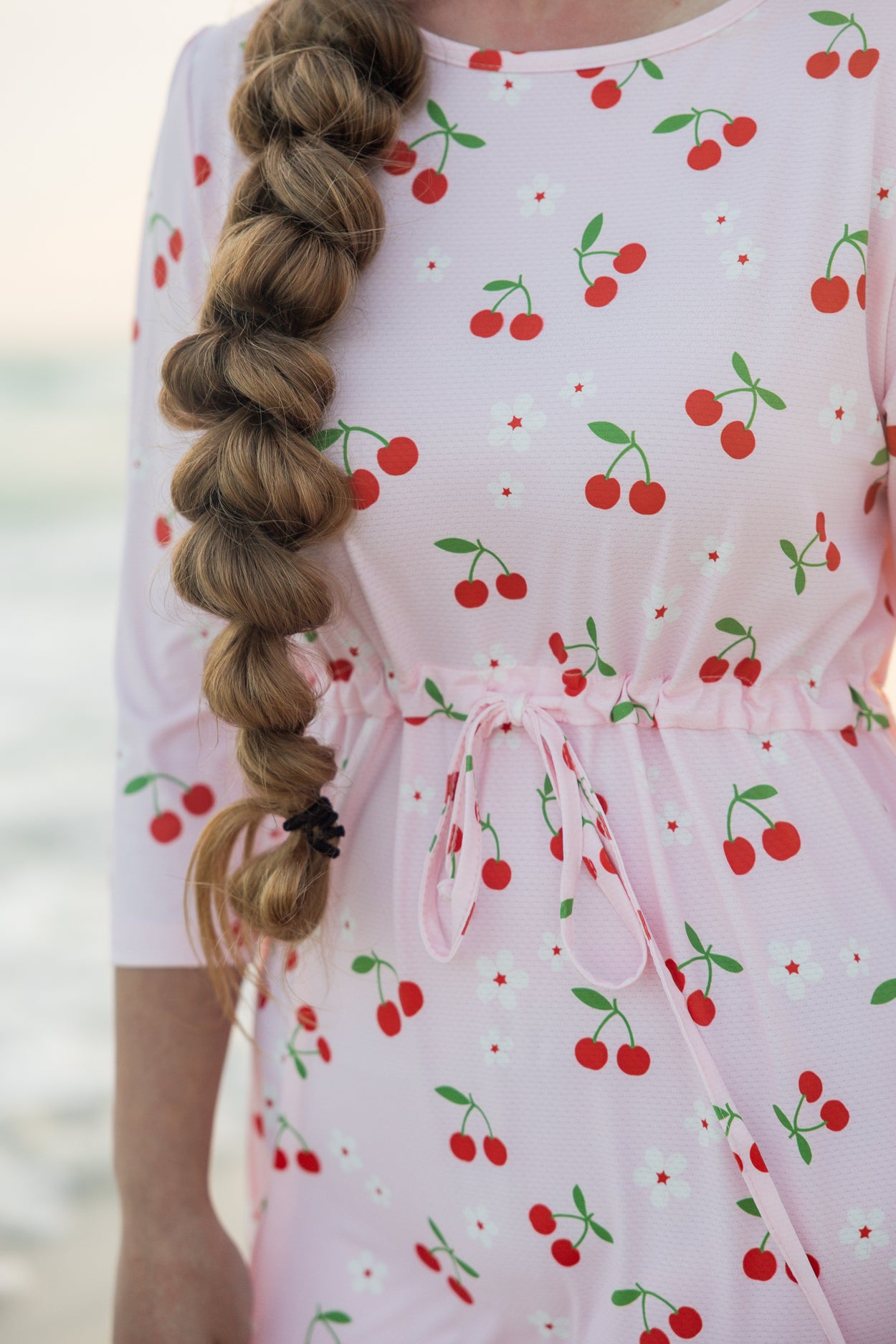 Model wearing Nuggles® Nola Sport Swim Dress in Cherry Soda Shop